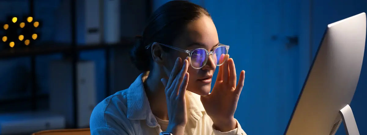 Adult using a laptop at home in daylight for a guide to blue light eye strain and screen comfort