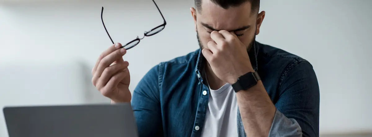Person taking a break from a laptop during a screen-heavy day to ease digital eye strain