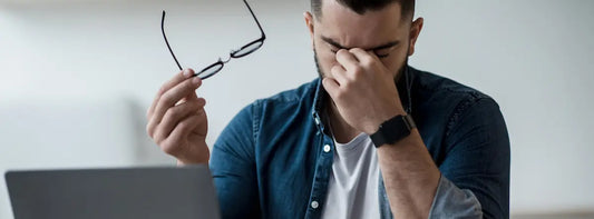 Person taking a break from a laptop during a screen-heavy day to ease digital eye strain