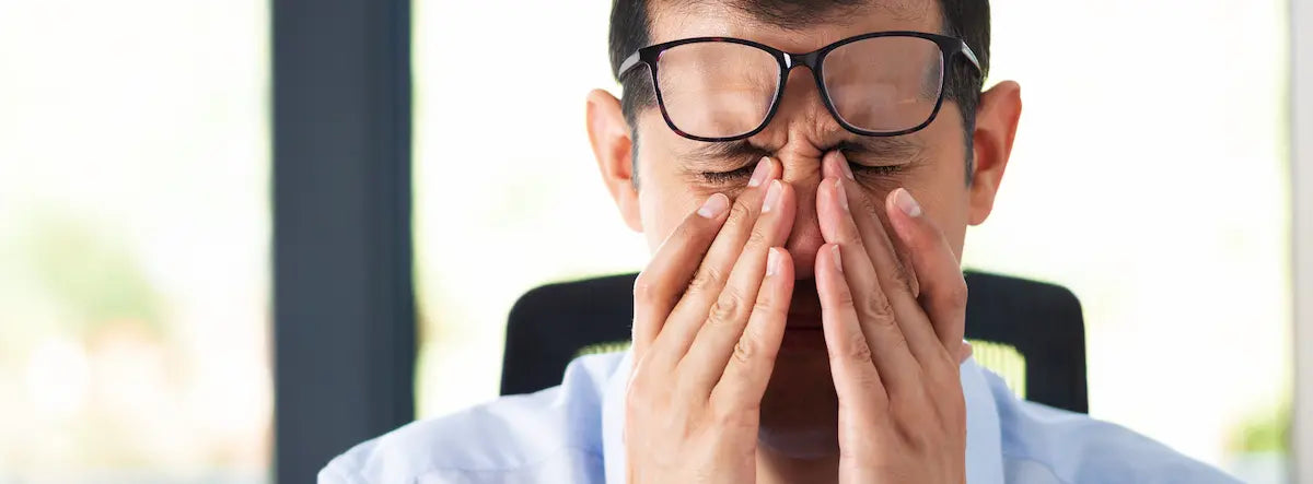Adult taking a screen break at a laptop while considering lutein for eye strain support