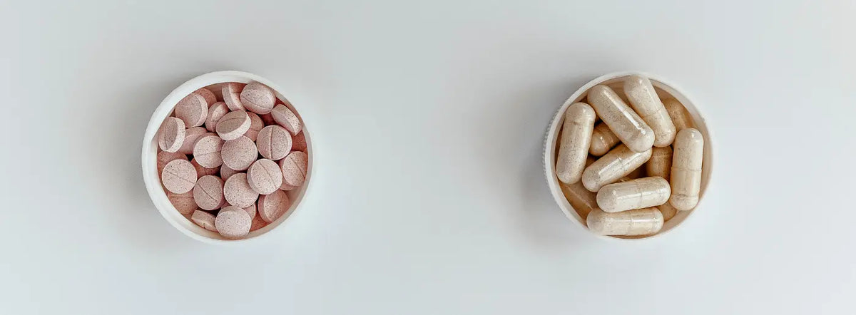 Vitamin B12 supplement capsules beside a bottle and glass of water in a bright, welcoming home setting.