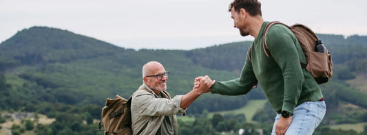 Older New Zealand man and adult family member comparing nettle, willow herb and horsetail beside a Gold Health-style supplement bottle
