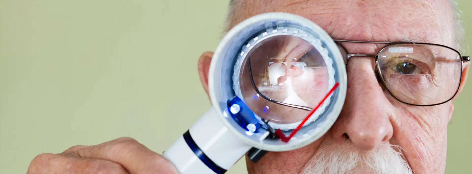 Reading glasses beside an Amsler grid used to check for wavy lines and central vision distortion.