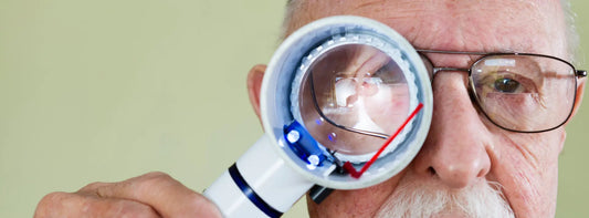 Reading glasses beside an Amsler grid used to check for wavy lines and central vision distortion.